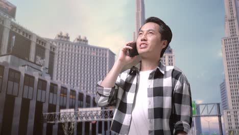 asian man freelancer looking at smartphone and shaking his head having a headache while standing in front of buildings working in a city