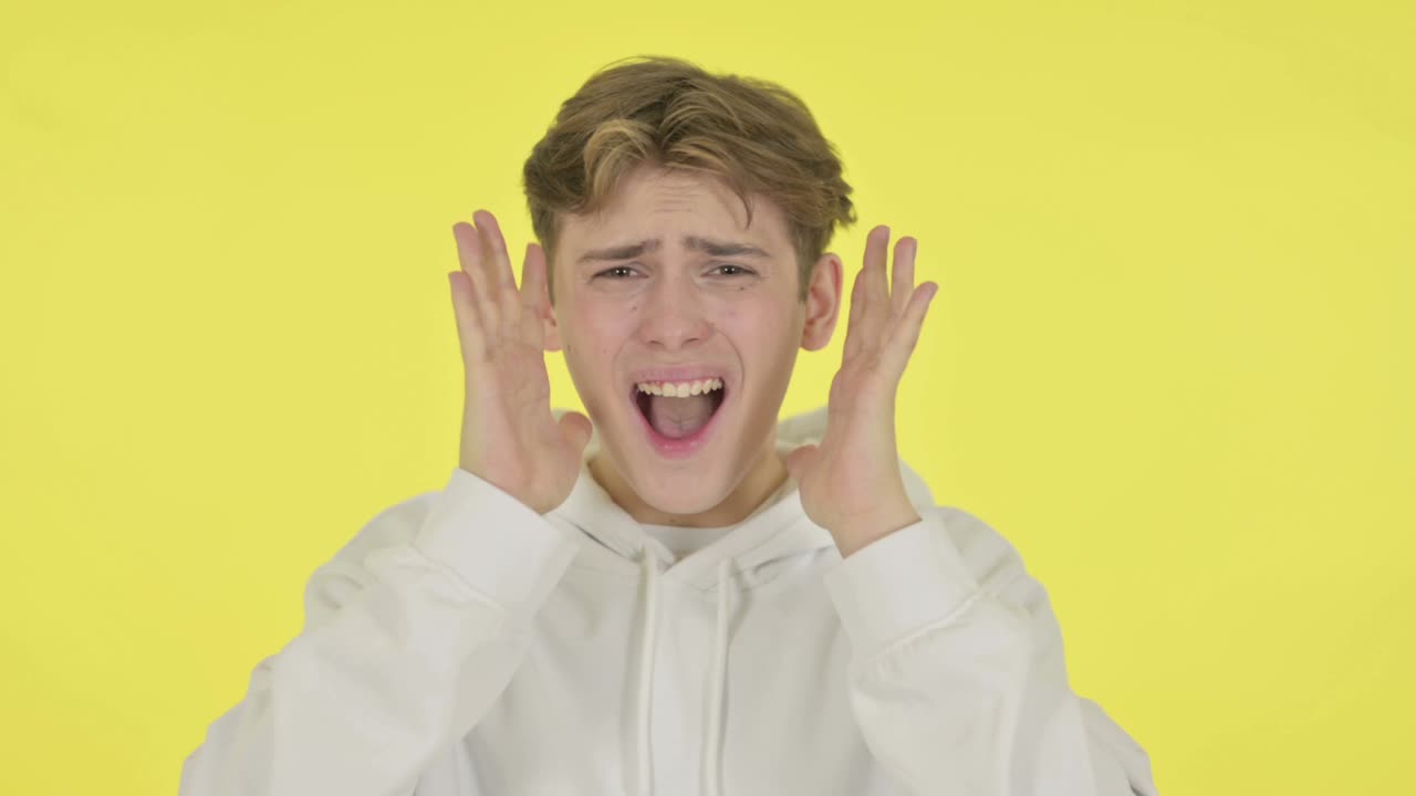 노란색 배경에서 소리치고 비명을 지르는 젊은이