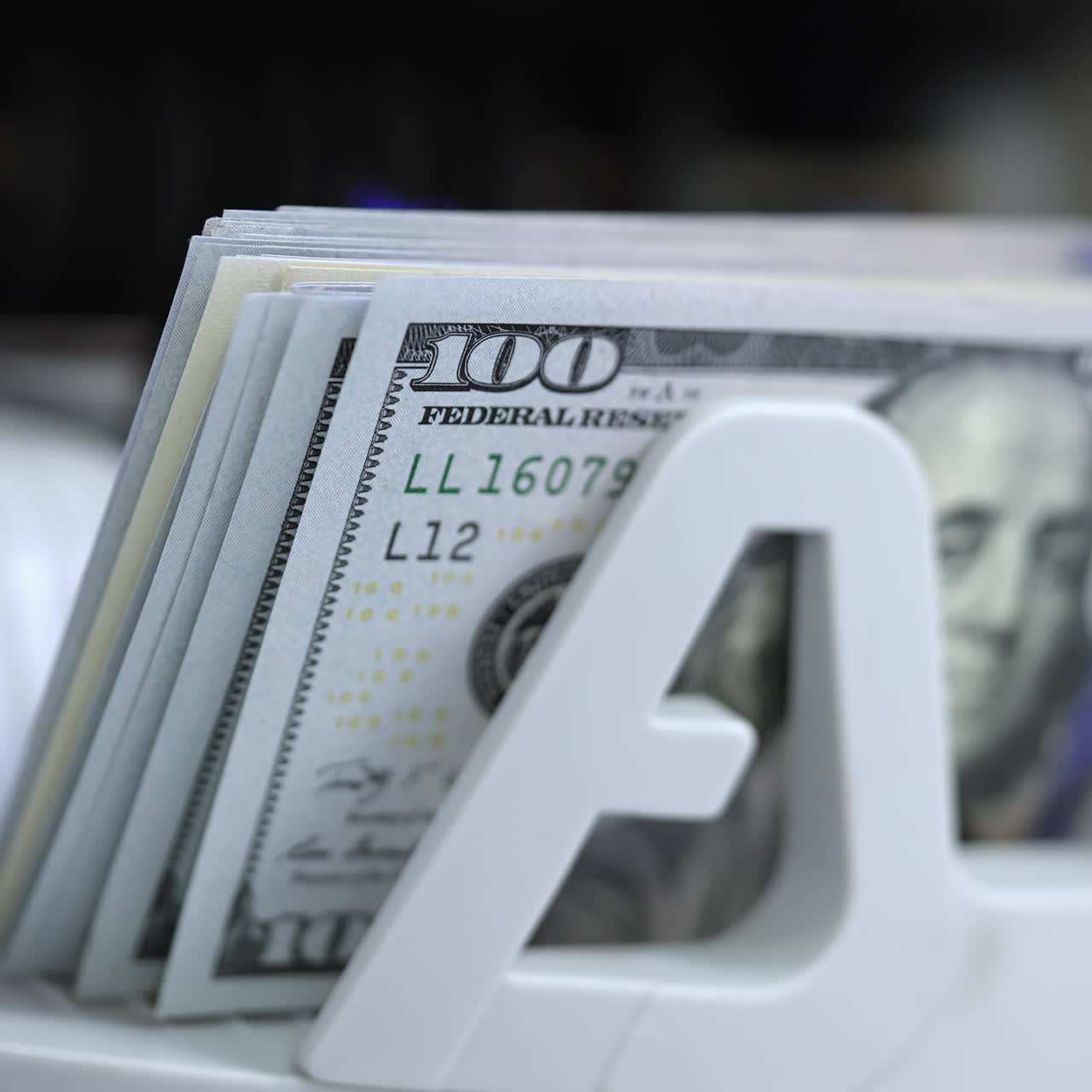 Money counting equipment for paper money calculation. Automatic mechanism for bank financial operations. Currency exchange of one hundred usd. Closeup currency counting machine counting dollar bills