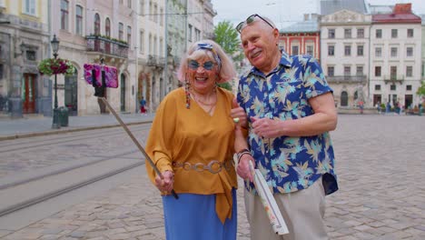 senior stylish blogger tourists man woman taking selfie photo, making video call on mobile phone