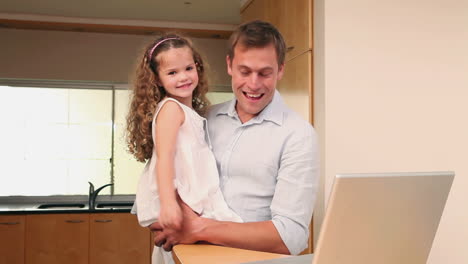 Padre-E-Hija-Con-Laptop-En-La-Cocina