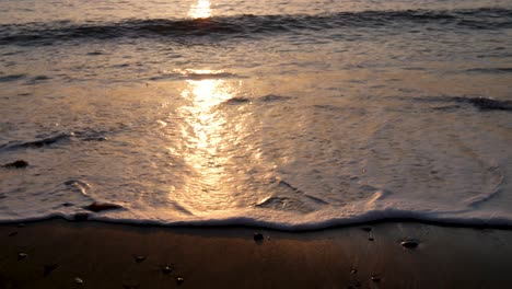 slow motion of waves crashing onto beach at sunset