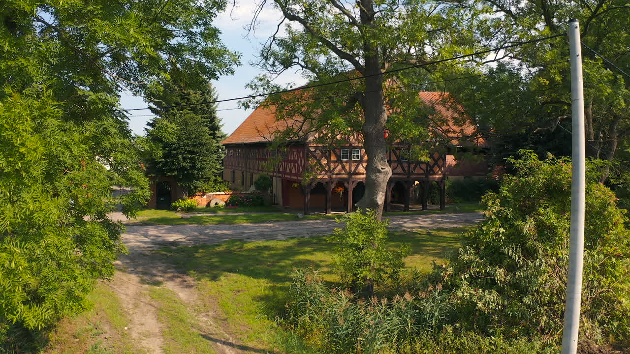 Aerial shot of trees and Charming Mennonite arcade house in Poland's historic town, a glimpse of timeless architecture