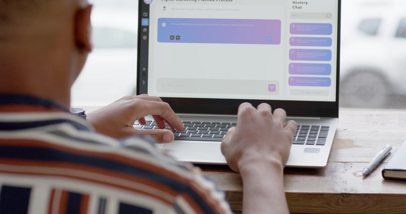 Placing hands on keyboard, man is typing reply on laptop at wooden table, purple bubble updating
