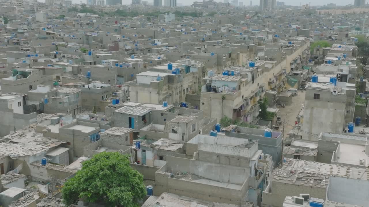 vista aérea de los edificios residenciales en el área de las líneas en karachi con tanques de agua de plástico azul en los techos