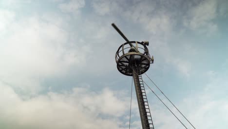 a rotating radar tower is scanning the area for flights and naval ships around the area in a cloudy day during daytime as the clouds move