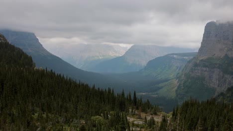 Wolken-Und-Nebel-Ziehen-über-Das-Tal-Mit-Den-Wunderschönen-Gletschergeschnitzten-Bergen,-Die-Hoch-Im-Gletscher-nationalpark-Westlich-Des-Logans-passes-Stehen