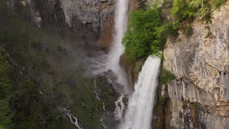 cascading waterfalls flowing down rocky cliffs surrounded by lush greenery in amden, walensee, switzerland