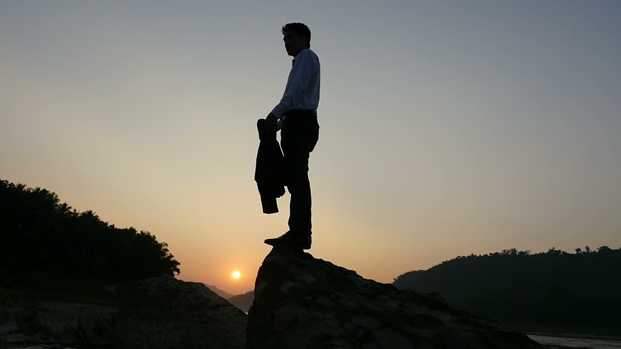 Businessman Silhouette at Sunset on a Rock