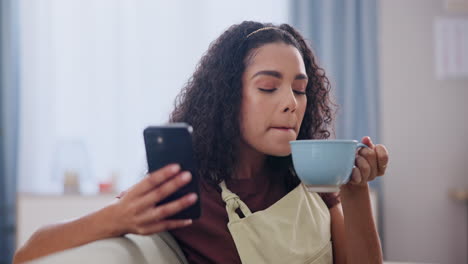 mujer relajándose en casa, bebiendo café y usando su teléfono