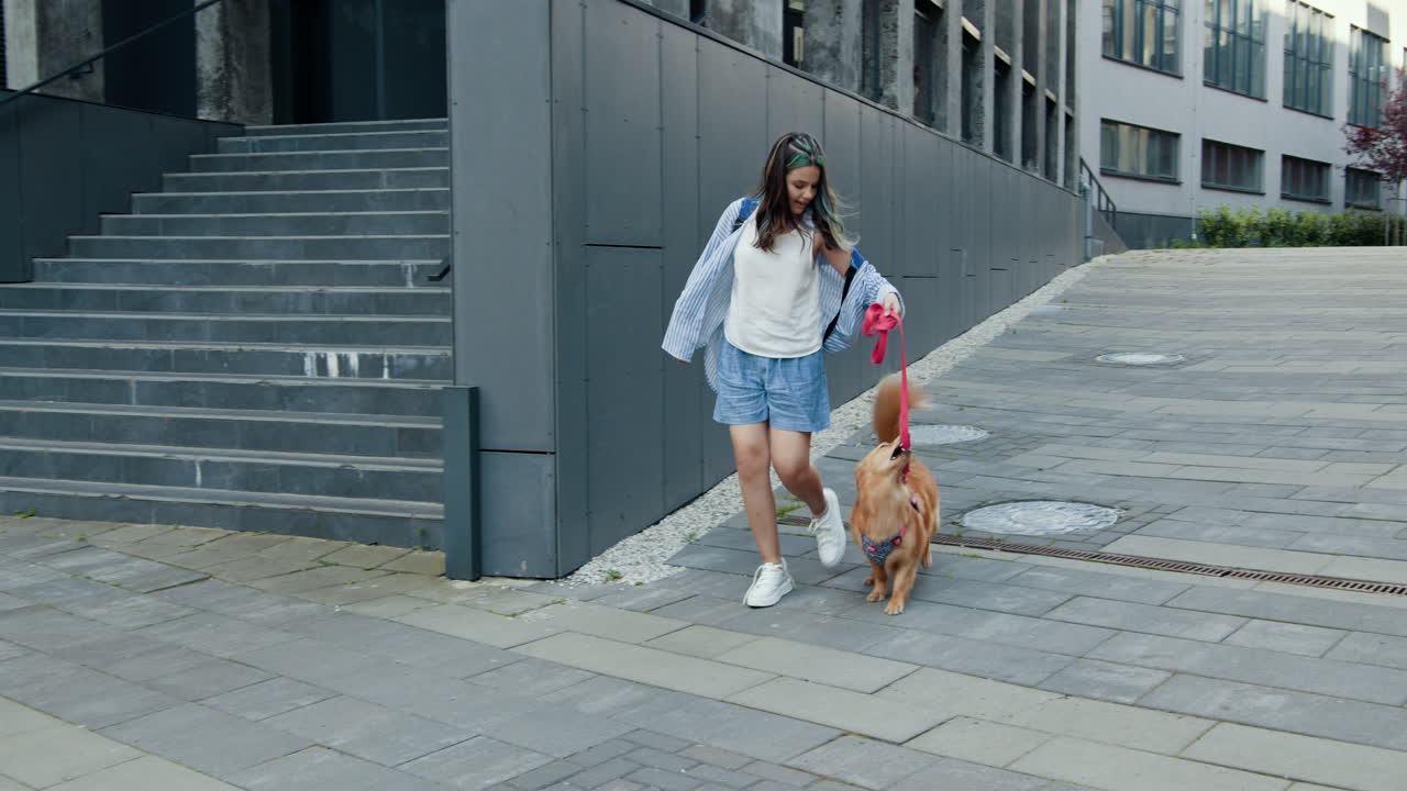 adolescente paseando a su perro por la ciudad