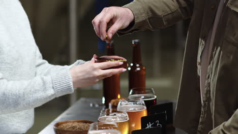 man touching hop and malt in bowls