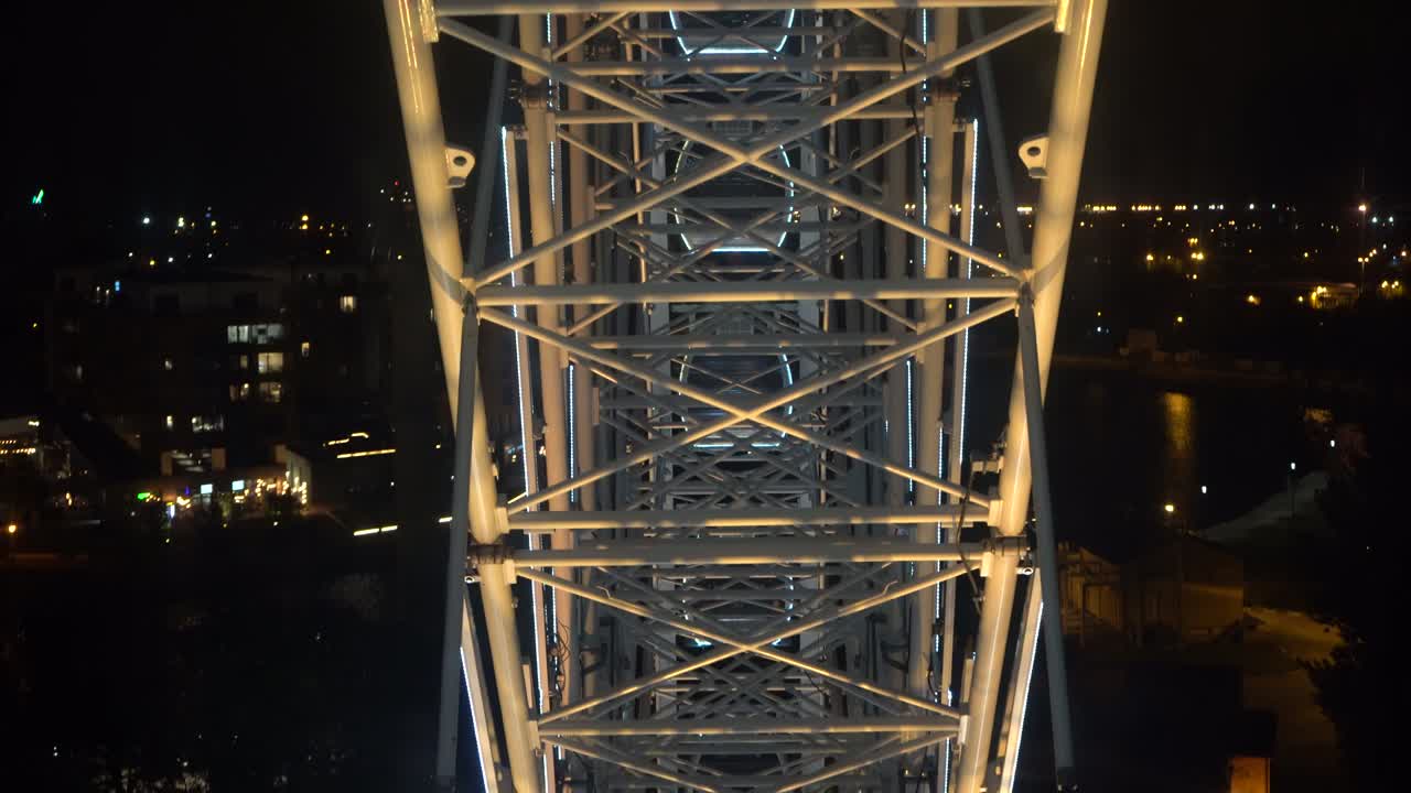 페리스 은 밤하늘을 배경으로 회전합니다. 밤의 조명을 가진 페리스 바의 클로즈업. 어두운 밤하늘 배경에 회전하는 조명 된 페리스  wheel 건설.