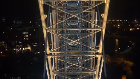 rueda gigante. una rueda gigante gira contra el fondo del cielo nocturno. primer plano de una rueda enorme con iluminación nocturna. construcción de rueda gigante iluminada girando contra el fondo oscuro del cielo nocturn.