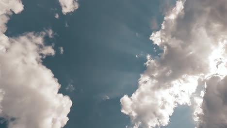 blue sky with beautiful textured clouds and sun light rays shining through on a sunny summer day