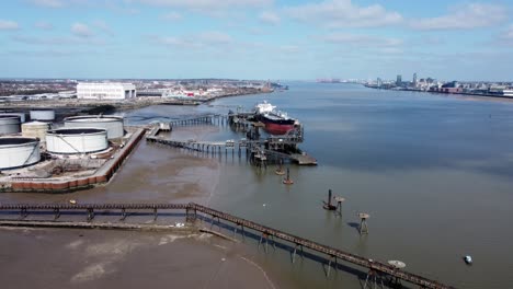 crude oil tanker ship loading at refinery harbour terminal aerial slow left dolly view