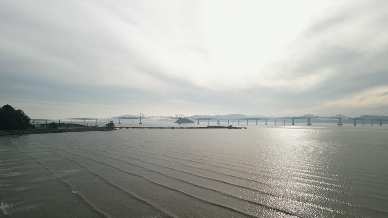 Aerial drone view of the Richmond–San Rafael Bridge stretching over the bay near Point Molate Beach.