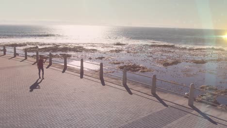 light spot against aerial view of african american fit woman running on the promenade