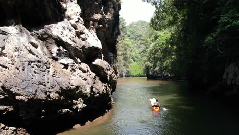 a kayaker paddling around a limestone rock on a river in ao thalane krabi thailand surrounded by mangroves