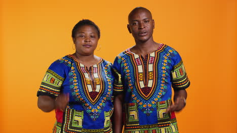 confident ethnic couple showing stop sign in studio