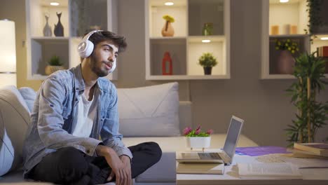 man dancing at night while listening to music at home.