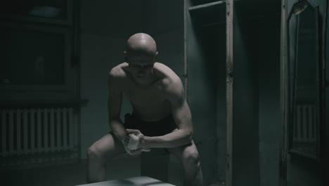 pale bald skinny man badnages his hands in the creepy old bathroom at night