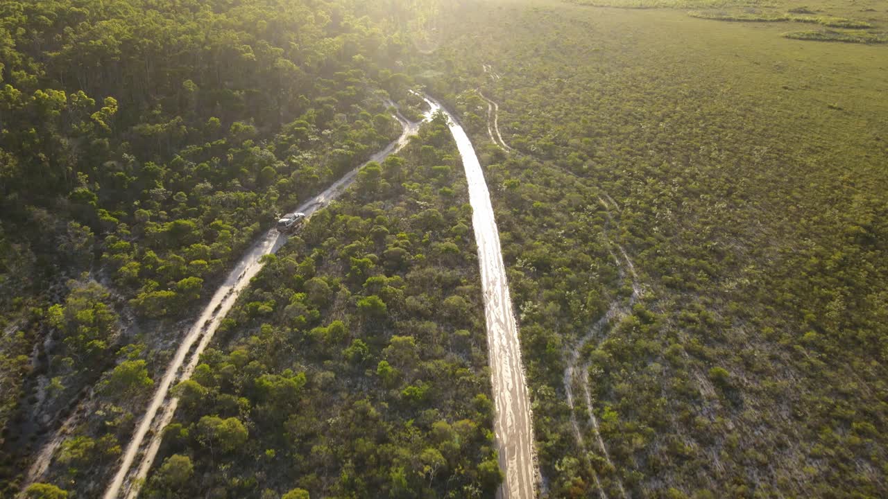 clip aéreo de 4x4 conduciendo lentamente en el remoto interior de australia, tarde en la tarde en la pista de arbusto, clip cuatro
