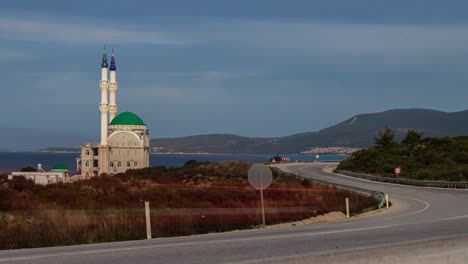 traffic, time-lapse, mosque and minarets near the road and sea in the turkish city izmir