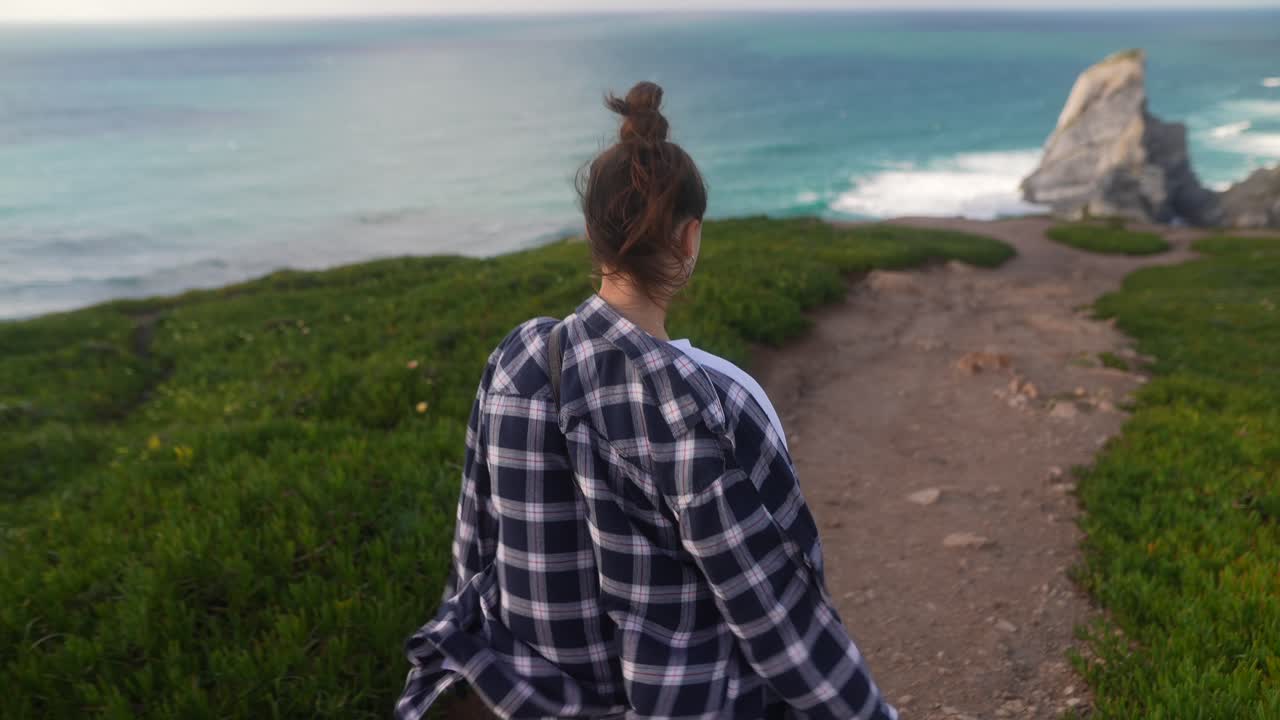 Woman Hiking Along the Coastline