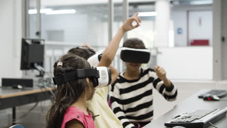 multiethnic children wearing virtual reality glasses in classroom