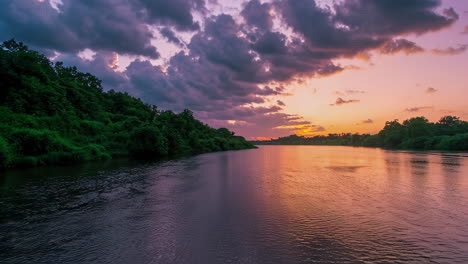 sunset over a river with lush forest