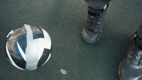 overhead view of sportsman demonstrating controlled right ankle movements with soccer ball on ground, agility, and coordination on textured sports surface in outdoor training setting