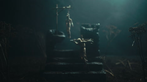 a miniature scene of the mummified dolls hanging on the gallows at night