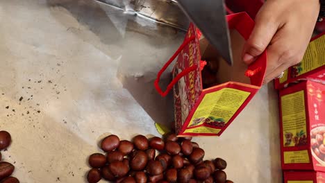 sequential packaging of chestnuts into boxes.