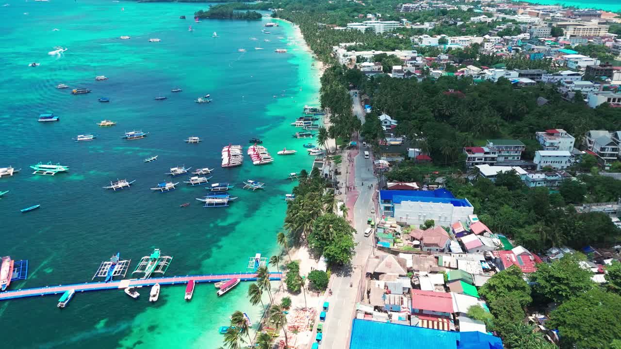 Aerial of Boracay, Philippines showcasing vibrant turquoise waters, anchored boats, and palm-lined coastline. Perfect for travel, tourism, and tropical paradise visuals
