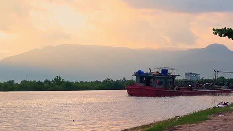 Un-Barco-Dragador-Dragando-Arena-En-La-Orilla-Del-Río-En-Kampot,-Camboya