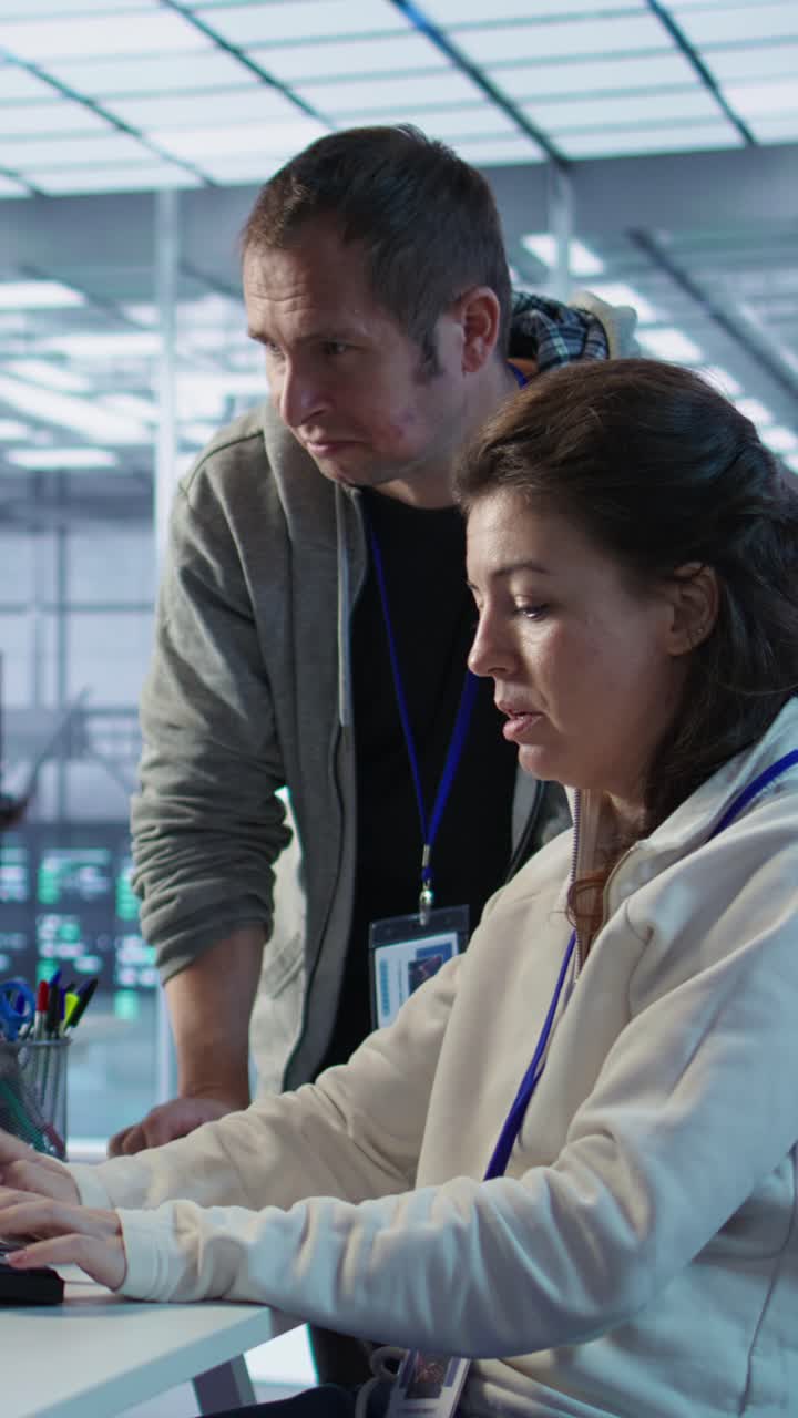 Vertical video Woman requesting help from senior engineer to fix error in high tech data center
