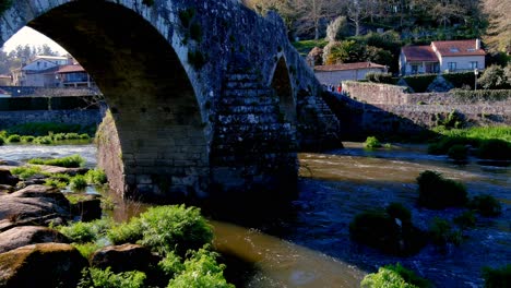 aerial view of stone arches of bridge of ponte maceira over the river tambre