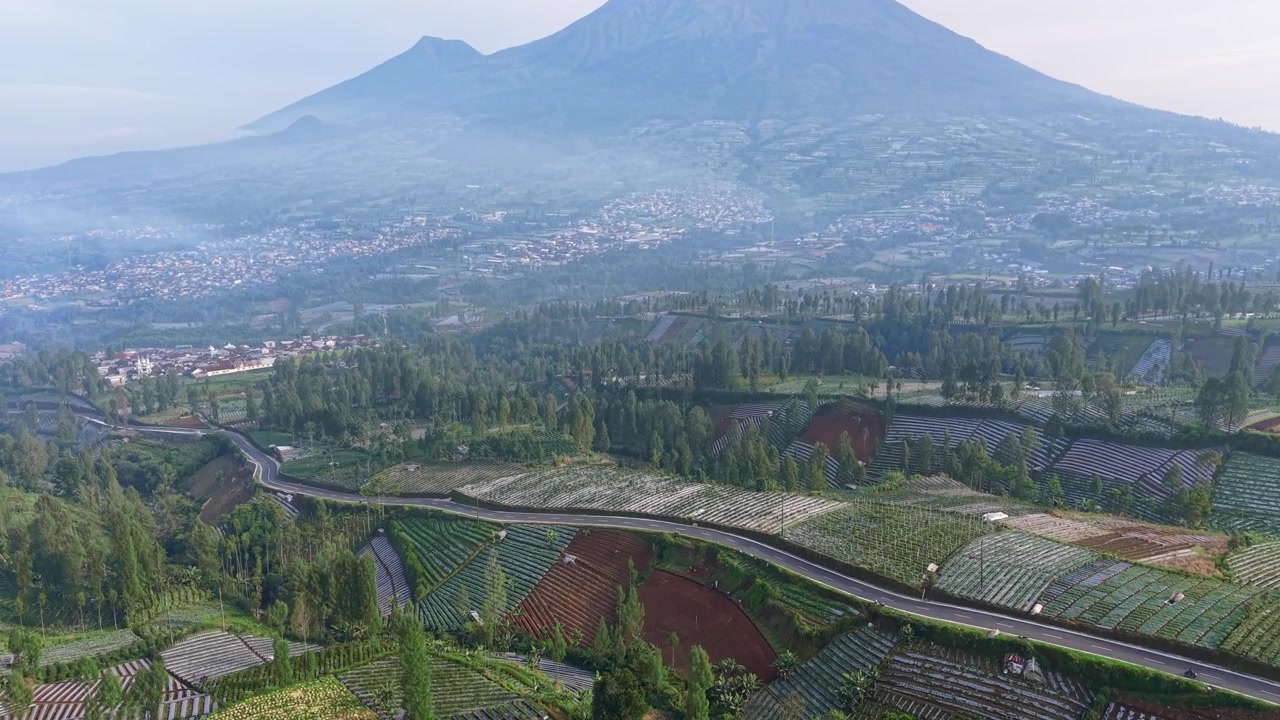 Hermoso paisaje montañoso con carretera sinuosa y campos agrícolas, escenario rural aéreo, concepto de viaje y naturaleza.