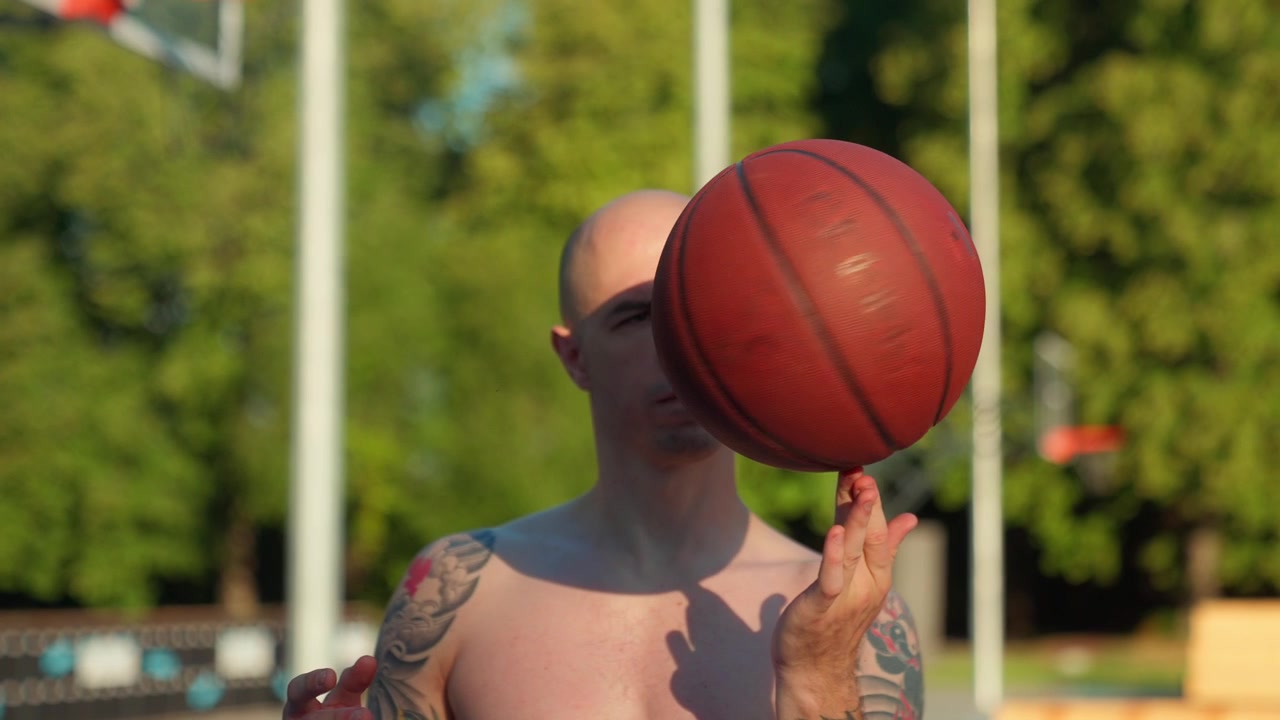 Tişörtsüz, Dövmeli Kel Adam Parmağında Basketbol Topu Çeviriyor