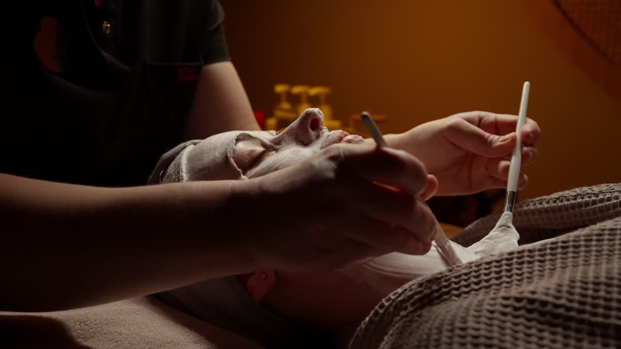 Kvinde får ansigtsmaskebehandling i et afslappende spa