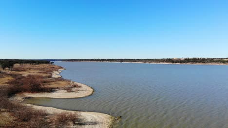 Elevándose-Sobre-La-Costa-Irregular-A-La-Izquierda-Para-Revelar-Una-Interesante-Línea-Contorneada-Del-Lago