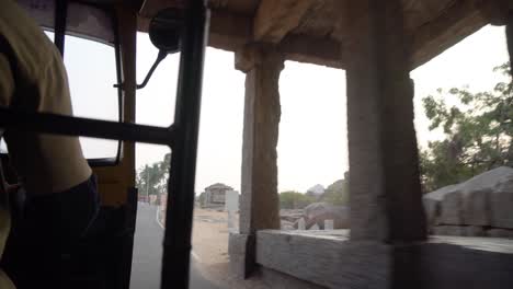 inside auto rickshaw view of stone temple ruins, hampi, india, karnakata