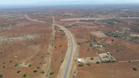 Pluma-Abajo-De-Una-Larga-Carretera-En-El-Campo-Rústico-De-Kenia