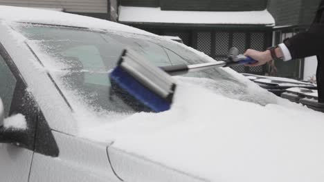 a man clearing away the ice covering the windshield of his car - close up shot