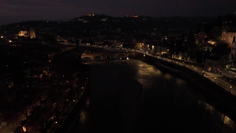 Toma-Aérea-Lateral-Delantera-Con-Drones,-Del-Puente-Ponte-Pietra-En-Verona-Por-La-Noche