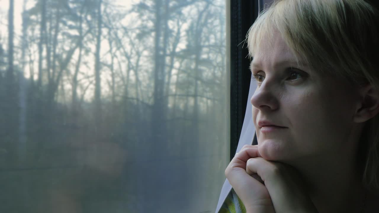 Portrait Of A Young Woman Traveling In A Train Looking Out The Window The Sun's Rays Illuminate Her 