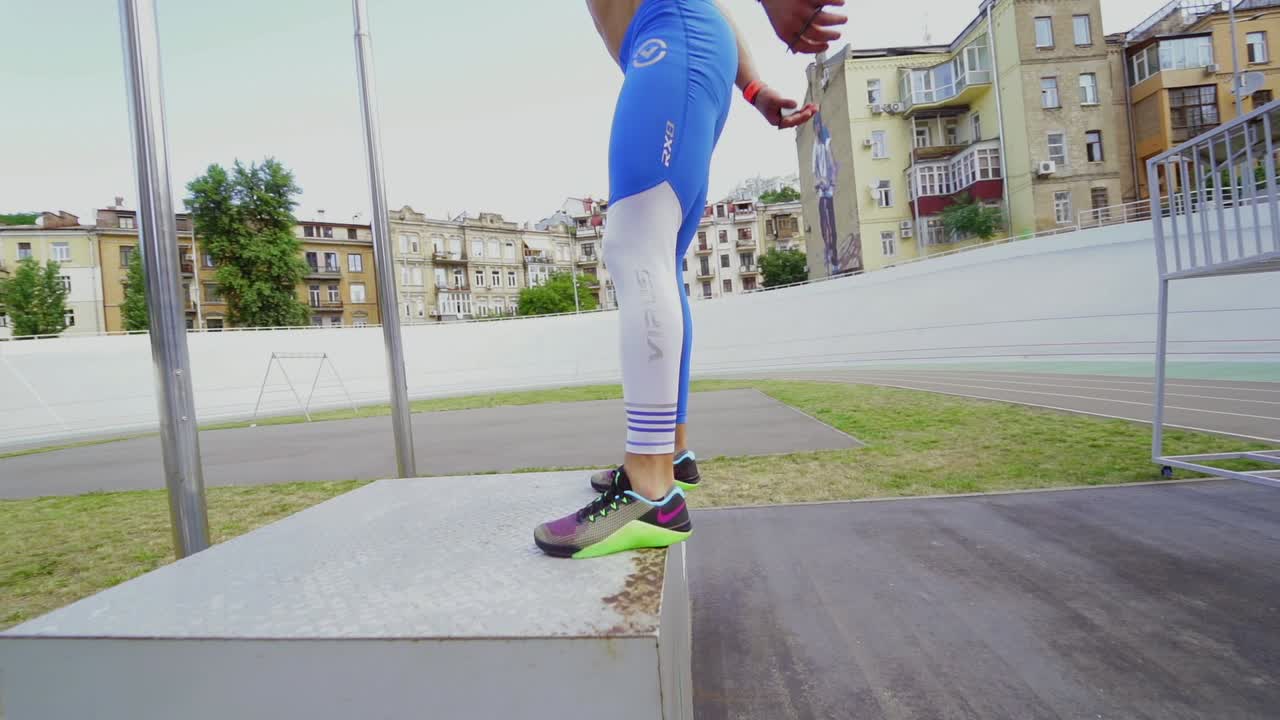 운동 선수 가 트랙 에서 박스 점프 를 하고 있다