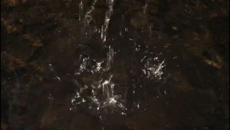 Close-up-footage-of-a-small-waterfall-flowing-over-river