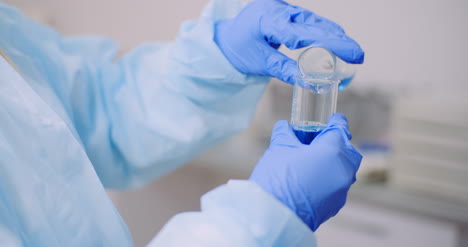 Female-Scientist-Holding-Tubes-And-Flask-With-Liquid-In-Hands-8